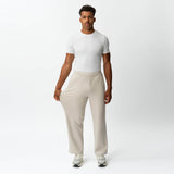 Full-body view showing the stretch of the beige Socrates wide-leg pant fabric