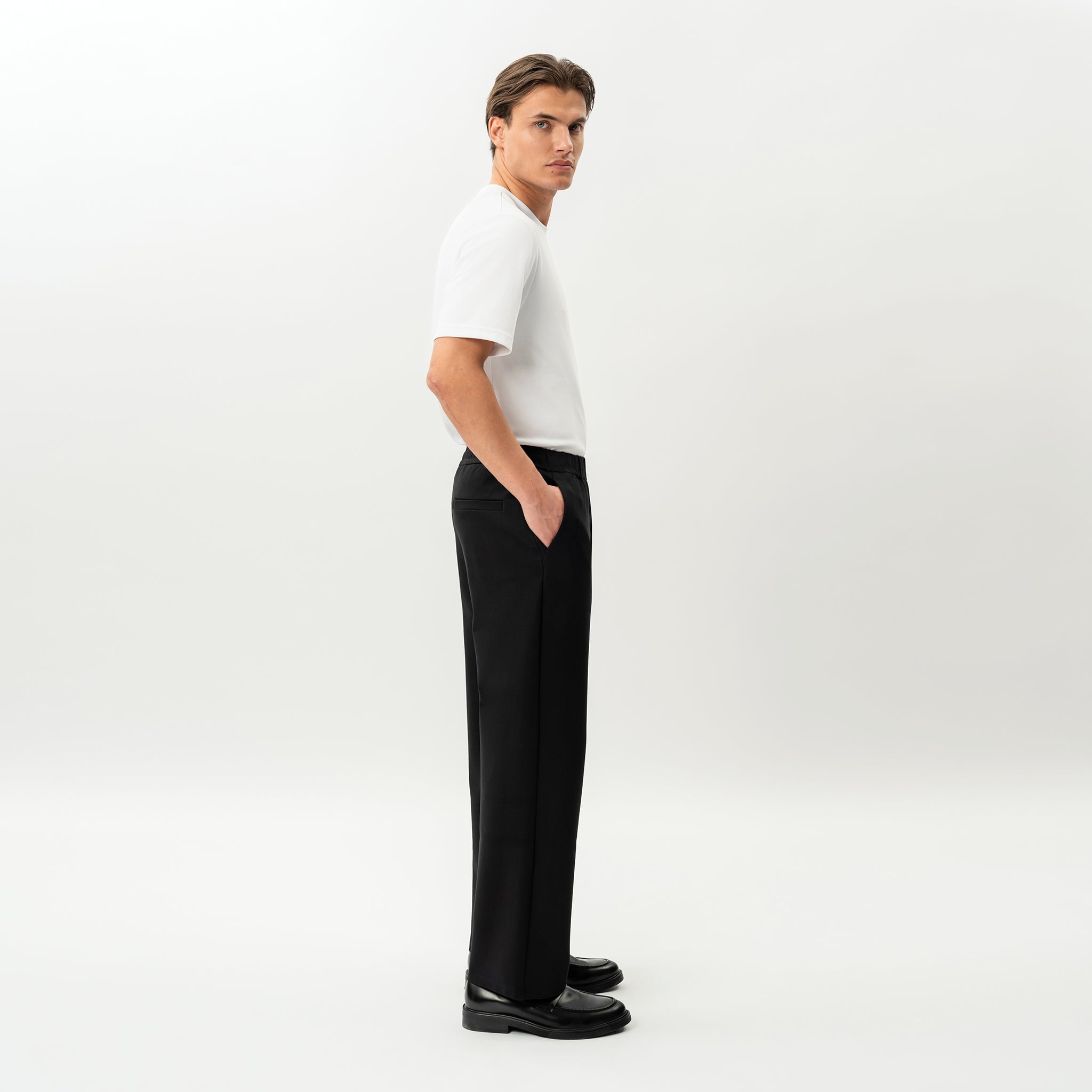 Side view of the Socrates wide-leg pant in black showing relaxed leg shape
