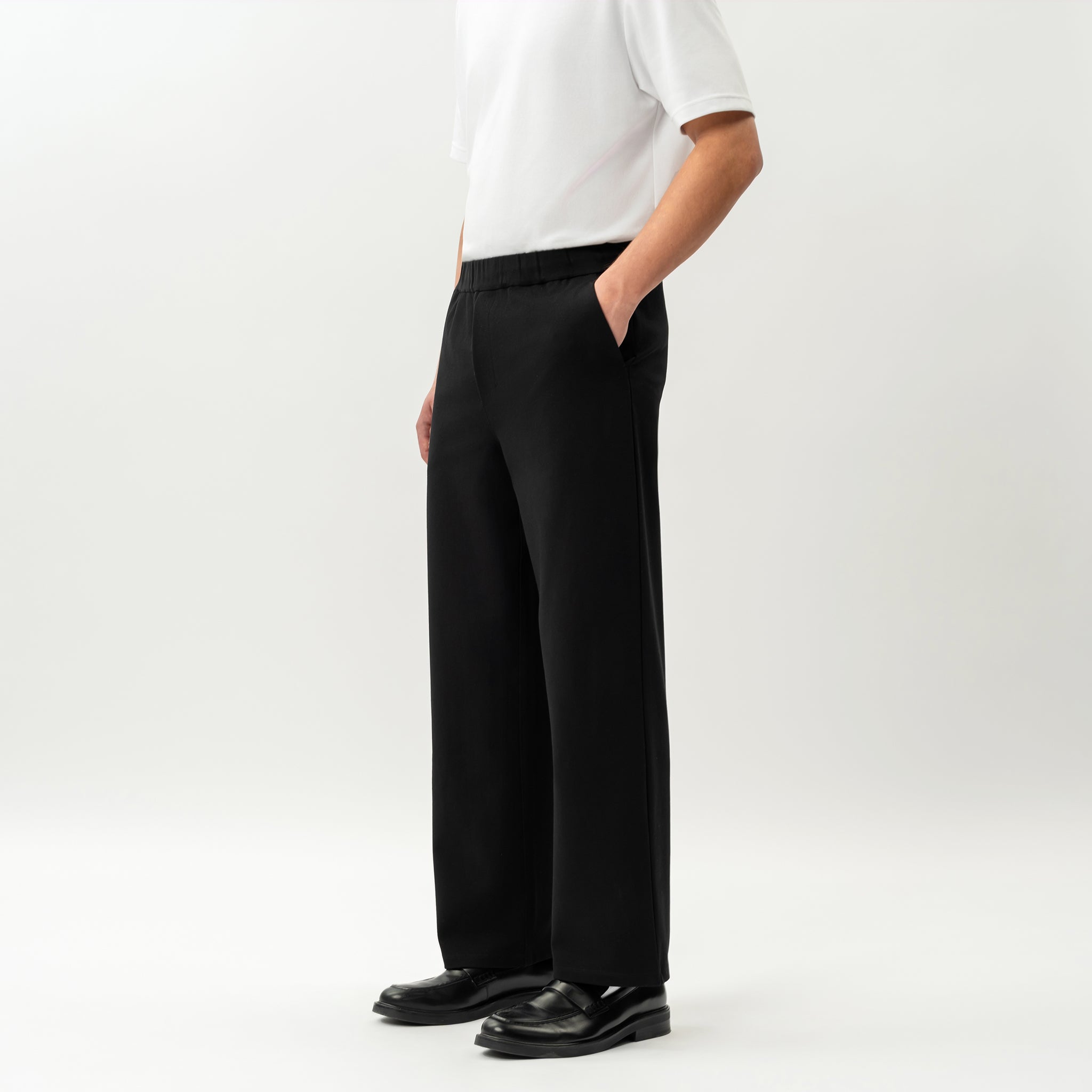 Side view of the Socrates wide-leg pant in black showing relaxed leg shape