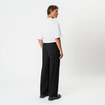 Angled back view of the black Socrates wide-leg pleated pant